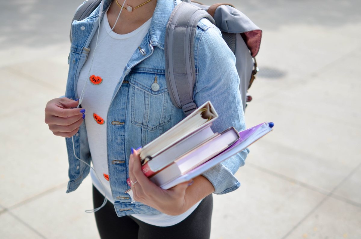 Une étudiante portant ses ouvrages de droit